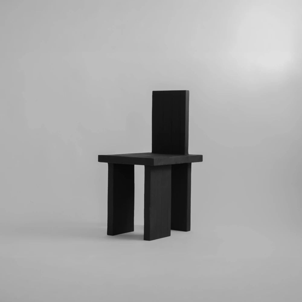 Three-quarter view of the Itooraba Chair by Sizar Alexis, showing its tall backrest, square seat and three geometric slab legs.